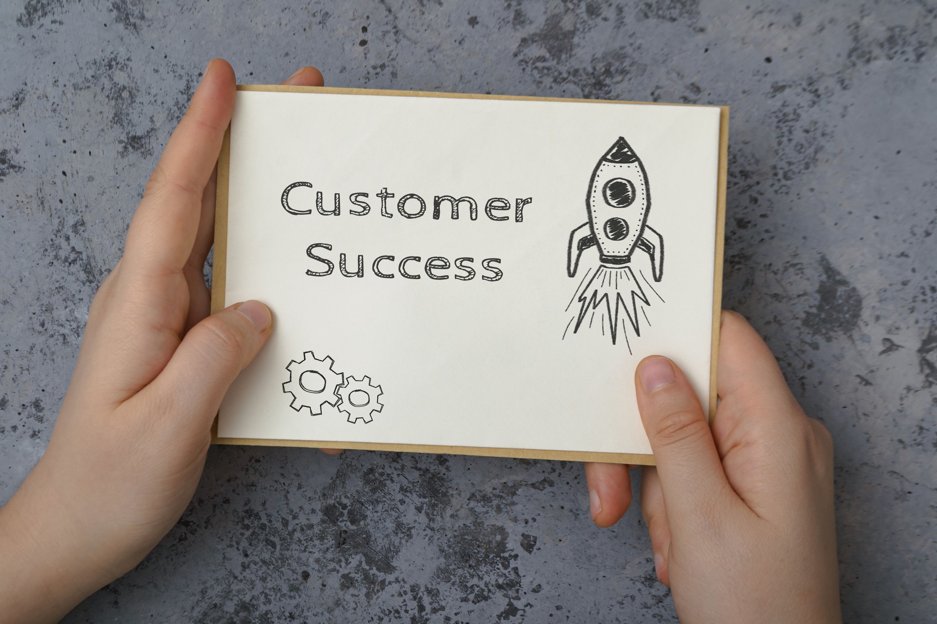 Woman holds card with words Customer success on concrete
